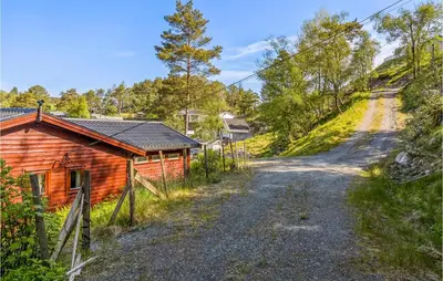 a dirt road next to a log cabin at Cozy Home In Sveio With Wifi in Sveio