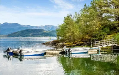 two boats are docked at a dock on a lake at Awesome Home In Etne With Sauna in Erve