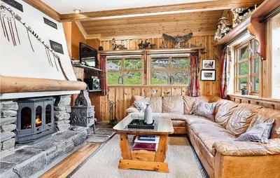 a living room with a couch and a fireplace at Awesome Home In Etne With Sauna in Erve
