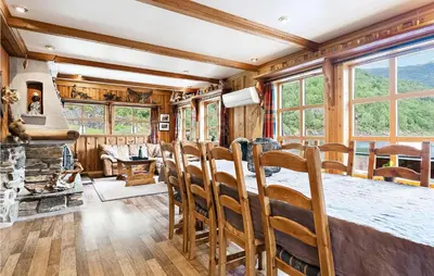 a living room with a fireplace and a table and chairs at Awesome Home In Etne With Sauna in Erve