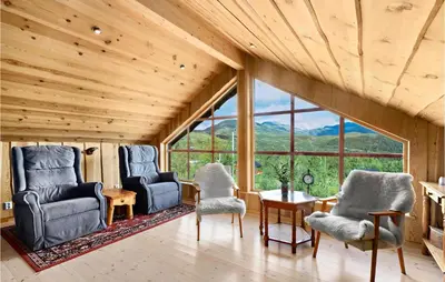 a room with two chairs and a table and windows at Cozy Home In Norheimsund With Sauna in Norheimsund