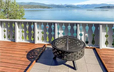 a table on a balcony with a view of the water at Beautiful Home In Jondal in Jondal