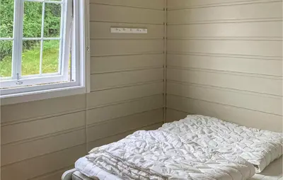 a bed in a corner of a room with a window at Beautiful Home In Jondal in Jondal