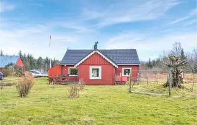 a red house with a black roof in a field at Amazing Home In Fonnes With Wifi in Fonnes