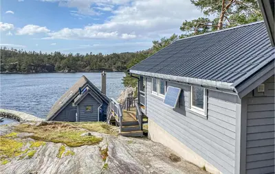 two buildings on the shore of a body of water at 3 Bedroom Stunning Home In Masfjorden in Masfjorden
