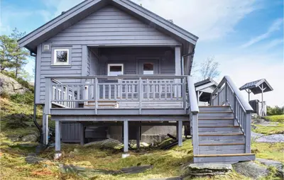 a gray house with a large porch and stairs at 3 Bedroom Stunning Home In Masfjorden in Masfjorden