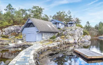 a house on a hill next to a body of water at 3 Bedroom Stunning Home In Masfjorden in Masfjorden