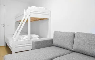 a couch in a living room with a bunk bed at Gorgeous Home In Stolmen With Kitchen