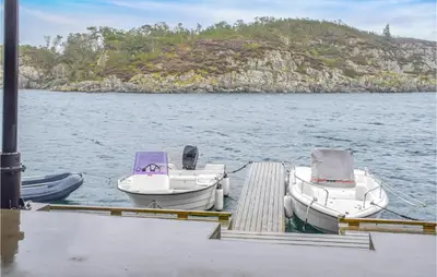 two boats are docked at a dock in the water at Gorgeous Home In Stolmen With Kitchen