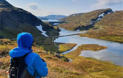 a person standing on a hill looking down at a lake at 3 Bedroom Amazing Home In Vossestrand in Vossestrand
