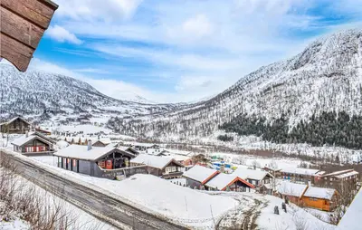 a village covered in snow with mountains in the background at 3 Bedroom Amazing Home In Vossestrand in Vossestrand