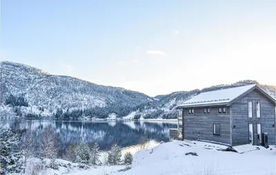 a cabin in the snow next to a lake at Lovely Home In Masfjordnes With Wifi in Masfjorden