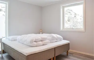 a bed with white blankets on top of it at Lovely Home In Masfjordnes With Wifi in Masfjorden