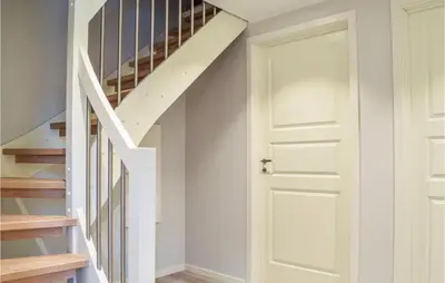 a hallway with a white door and stairs at Lovely Home In Masfjordnes With Wifi in Masfjorden