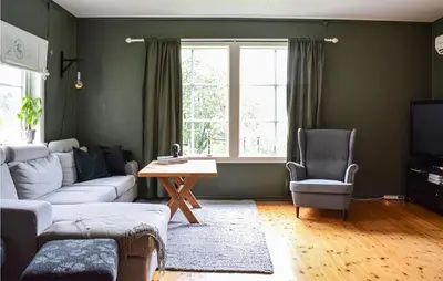 a living room with a couch and a table and a window at Beach Front Home In Tysse With Wifi in Tysse