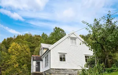 a white house on a hill with trees at Beach Front Home In Tysse With Wifi in Tysse
