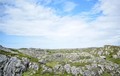 a rocky hillside with a blue sky and clouds at 2 Bedroom Cozy Home In Stolmen