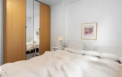 a bedroom with a white bed and a mirror at 2 Bedroom Nice Home In Fana in Fanahammaren