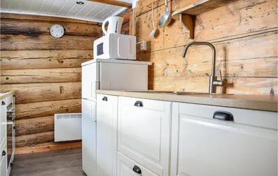 a kitchen with wooden walls and a sink at Pet Friendly Home In Evanger in Evanger
