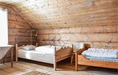 two beds in a room with wooden walls at Pet Friendly Home In Evanger in Evanger