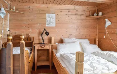a bedroom with two beds in a wooden wall at Pet Friendly Home In Evanger in Evanger
