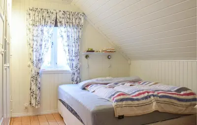 a bed in a room with a window at Gorgeous Home In Fjell With Wifi in Lokøy