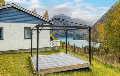 a gazebo in front of a house next to a lake at Nice Home In Byrkjelo With Kitchen in Byrkjelobrua
