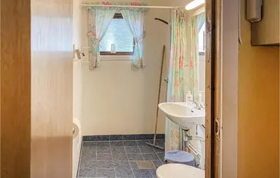 a bathroom with a sink and a toilet and a window at Nice Home In Byrkjelo With Kitchen in Byrkjelobrua
