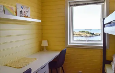 a yellow room with a desk and a window at Valvik in Tansøy