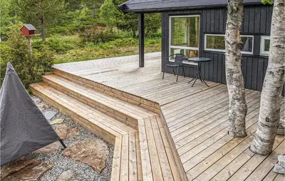 a wooden deck in front of a house at Cozy Home In Sykkylven With Kitchen in Sykkylven