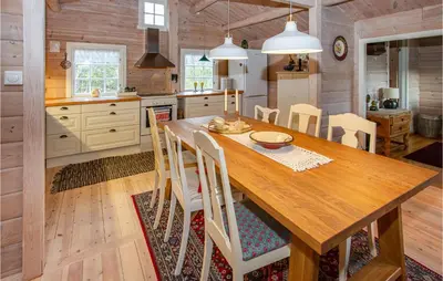 a kitchen and dining room with a wooden table and chairs at Cozy Home In Sykkylven With Kitchen in Sykkylven