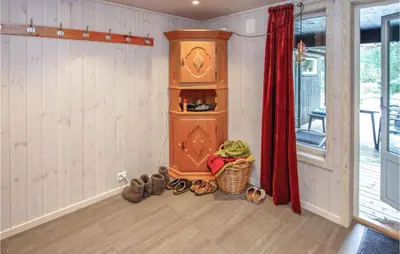 a room with a wooden cabinet and shoes in it at Cozy Home In Sykkylven With Kitchen in Sykkylven