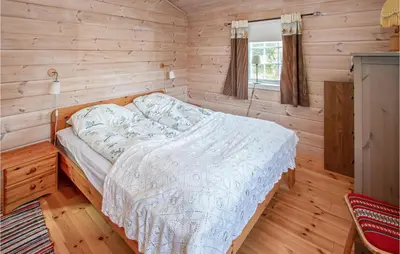 a bedroom with a bed in a wooden room at Cozy Home In Sykkylven With Kitchen in Sykkylven
