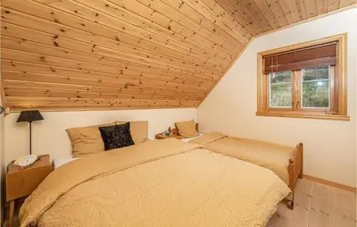 a bedroom with a bed and a window at Beach Front Home In Kvamsøy in Sandvik