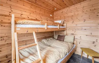 a bedroom with two bunk beds in a log cabin at Beach Front Home In Kvamsøy in Sandvik