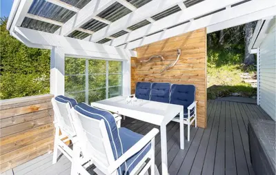 a white table and chairs on a wooden deck at 2 Bedroom Awesome Home In Isfjorden in Isfjorden