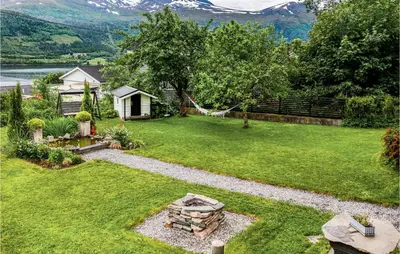 a backyard with a fire pit in the grass at Gorgeous Home In Vestnes With Wifi in Vestnes