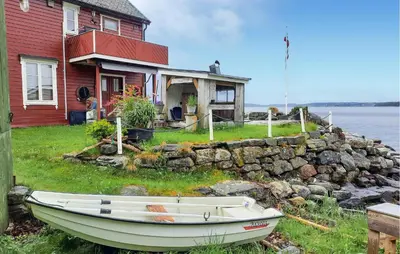 a boat sitting on the grass in front of a house at 2 Bedroom Stunning Apartment In Åfarnes in Åfarnes