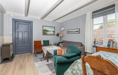 a living room with a blue door and a couch and a table at 2 Bedroom Stunning Apartment In Åfarnes in Åfarnes