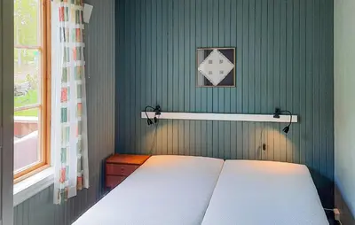 a bed in a bedroom with a green wall at 2 Bedroom Stunning Apartment In Åfarnes in Åfarnes