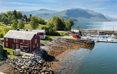 a red house next to a marina with a boat at 2 Bedroom Stunning Apartment In Åfarnes in Åfarnes
