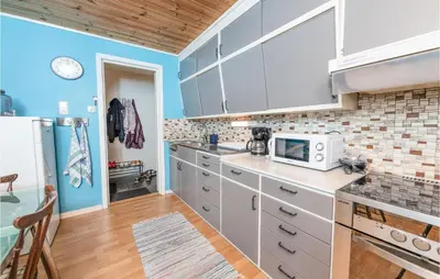 a kitchen with white cabinets and blue walls at 5 Bedroom Pet Friendly Home In Vestnes in Vestnes