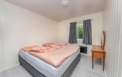 a bedroom with a bed and a desk and a window at 5 Bedroom Pet Friendly Home In Vestnes in Vestnes