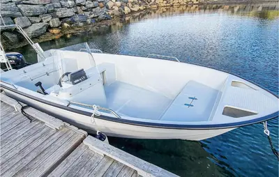 a white boat docked at a dock in the water at 3 Bedroom Beautiful Home In Øydegard in Aspa