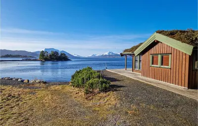 a building with a grass roof next to a body of water at 3 Bedroom Beautiful Home In Øydegard in Aspa