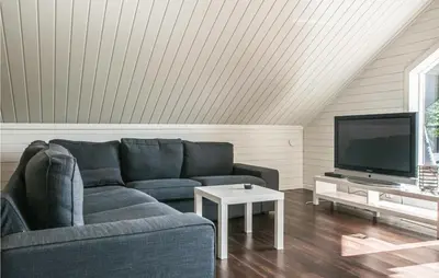 a living room with a blue couch and a tv at Gorgeous Home In Søre Osen With Wifi in Midskogberget