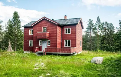 a red house in the middle of a field at Amazing Home In Tufsingdalen With Wifi in Bakken