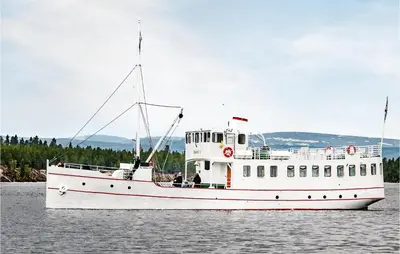 a white boat in the water with people on it at Amazing Home In Tufsingdalen With Wifi in Bakken
