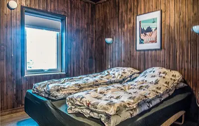 two beds in a room with wooden walls and a window at Lovely Home In Trysil With Wifi in Trysil