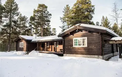 a log cabin with snow on the ground at Lovely Home In Drevsjø With Lake View in Drevsjø